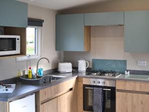 a kitchen with a sink and a stove top oven at The Falcon - Uk45538 in Dyke