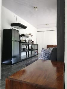 a living room with a table and a refrigerator at Casa Onca in Río Claro