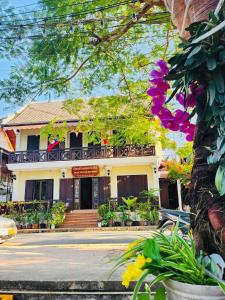 a house with flowers in front of it at Anisa Mekong Riverside Villa in Luang Prabang