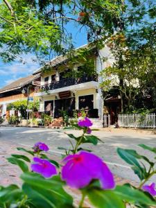 un edificio con fiori viola di fronte a una strada di Anisa Mekong Riverside Villa a Luang Prabang