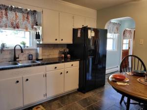 a kitchen with a black refrigerator and a table at Private space, while visiting family this Holiday! in Pottstown