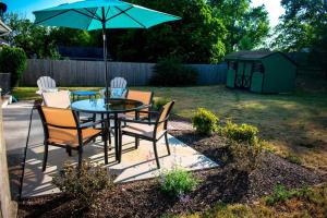 a table with chairs and an umbrella in a yard at Private space, while visiting family this Holiday! in Pottstown
