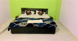 OYO Hotel Shubham Palace في عليكره: سرير عليه وسادتين في غرفة