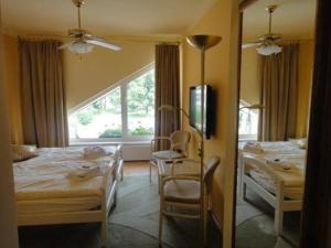 a bedroom with two beds and a desk and a mirror at Hotel Monaco in Náměšť nad Oslavou