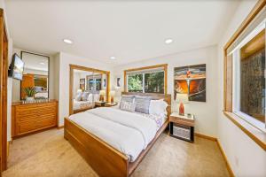 a bedroom with a large bed and a mirror at Sunlit Pines by Tahoe Getaways - 2BR in Tahoe Park w Hot Tub, Fenced Yard & Pet Friendly! in Tahoe City