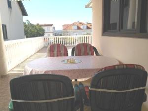 einen Tisch und 4 Stühle auf einem Balkon in der Unterkunft Apartments by the sea Biograd na Moru, Biograd - 21597 in Biograd na Moru