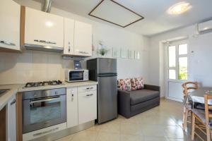 cocina con nevera de acero inoxidable y sofá en Apartments with parking space Risika, Krk - 21696, en Vrbnik