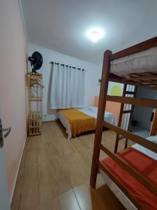 een slaapkamer met een stapelbed en een ladder bij Hospedagem Casa Girassol in Praia Grande