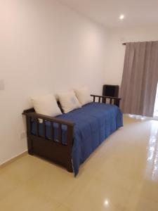 1 dormitorio con 1 cama con sábanas y almohadas azules en Departamento a estrenar GALO VII en San Bernardo