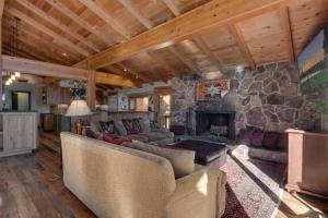 a living room with a stone fireplace in a house at Gray Bear Lake View Estate - Stunning Cabin w 4 Master Suites, Private Hot Tub! in Carnelian Bay