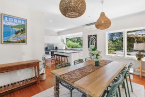 a kitchen and dining room with a wooden table and chairs at Coastal Charm in Lorne