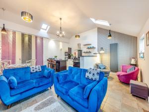 un soggiorno con divani blu e una cucina di Ty Menyn - Uk45716 a Brynteg