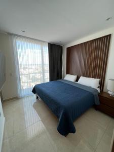 a bedroom with a bed and a large window at Apartment In Camino Al Mar with Amazing View of the Ocean, Beach and Swimming Pool in Mazatlán +42 photos