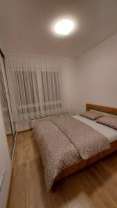 sypialnia z 2 łóżkami i lampką na suficie w obiekcie Apartman Kosmos w mieście Banja Luka