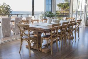 a dining room table and chairs with a view of the ocean at Kalinda in Mollymook