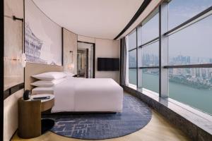1 dormitorio con cama y ventana grande en Wuhan Marriott Hotel Wuchang en Wuhan