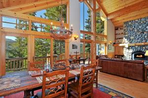una sala da pranzo con tavolo e camino di Sierra Crest at Palisades Tahoe - Secluded Luxury 5BR 5 BA w Wood Fireplace a Olympic Valley