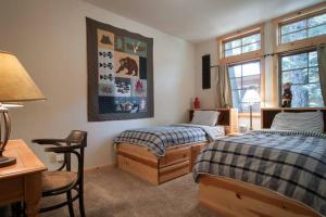 a bedroom with two beds and a table and a desk at Sierra Crest at Palisades Tahoe - Secluded Luxury 5BR 5 BA w Wood Fireplace in Olympic Valley