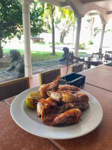 a plate of shrimp and vegetables on a table at Hotel Lagoon Paradise in Negombo
