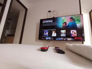 a computer mouse sitting on a bed with a television at Alex & Kamilo in Bucaramanga