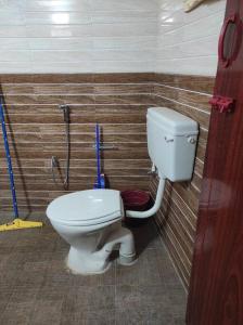 a bathroom with a white toilet in a room at Muktamma in Tiruvannāmalai +2 photos