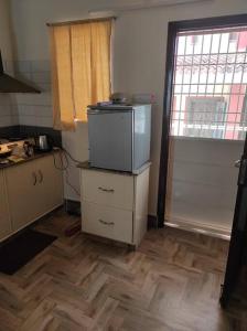 a kitchen with a refrigerator on top of a dresser at Muktamma in Tiruvannāmalai