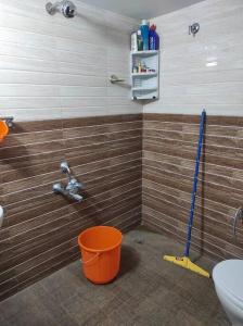 a bathroom with a toilet and a mop and a sink at Muktamma in Tiruvannāmalai