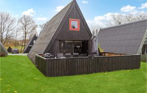 una casa negra con una ventana roja a un lado. en Amazing Home In Fars With Wifi en Farsø