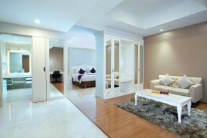 uma sala de estar com um sofá e uma cama em Platinum Hotel & Convention Hall Balikpapan em Balikpapan