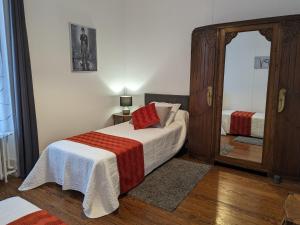 ein kleines Schlafzimmer mit einem Bett und einem Spiegel in der Unterkunft Gîte La Neuville-sur-Essonne, 4 pièces, 6 personnes - FR-1-590-107 in La Neuville-sur-Essonne