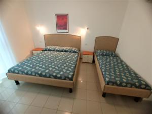 2 Betten in einem kleinen Zimmer mit in der Unterkunft Relax in the terrace of our flat - Beahost in Lignano Sabbiadoro