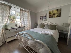 a bedroom with a white bed and a window at A Home from Home in Redditch near town centre in Redditch