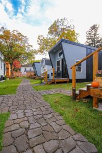 a cobblestone walkway leading to a house with benches at Tiny Digs Lakeshore - Tiny House Lodging in Muskegon