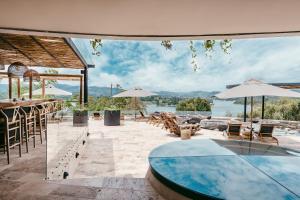 a patio with a pool and tables and umbrellas at The Brown, Guatape in Guatapé