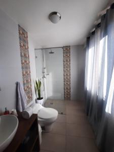 y baño con aseo y lavamanos. en Hotel Rincon Aleman en Riobamba