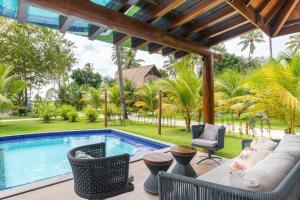 eine Terrasse mit einem Pool, Stühlen und einem Pool in der Unterkunft Bangalo eco resort carneiros in Tamandaré
