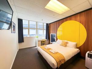 a bedroom with a large bed with a yellow headboard at Wellington Hotel in Wellington