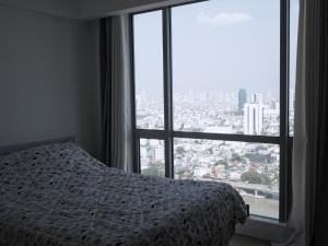 1 dormitorio con cama y ventana grande en Modern and Comfortable Staycation - Unit 3718 Novotel Tower en Manila
