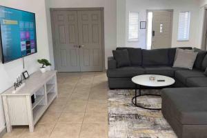 a living room with a couch and a flat screen tv at Spacious Getaway! Pool, Spa, Sleeps 9 in Lake Havasu City