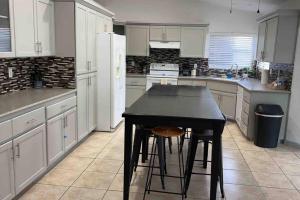 a kitchen with a black table and a white refrigerator at Spacious Getaway! Pool, Spa, Sleeps 9 in Lake Havasu City