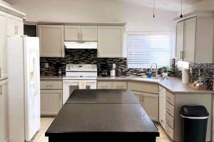 a kitchen with white cabinets and a black counter top at Spacious Getaway! Pool, Spa, Sleeps 9 in Lake Havasu City