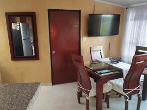 a dining room with a table and chairs and a television at Apartamento con vista a la ciudad en barrio campo hermoso 301 in Bucaramanga