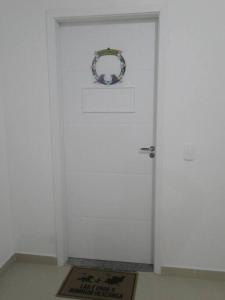 a white door with a wreath on top of it at Apto. aconchegante in Ubatuba