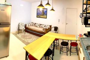 a kitchen and living room with a table and a couch at Apto. aconchegante in Ubatuba