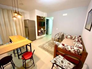 a living room with a couch and a table with chairs at Apto. aconchegante in Ubatuba