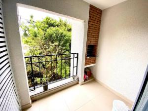 a room with a balcony with a large window at Apto. aconchegante in Ubatuba