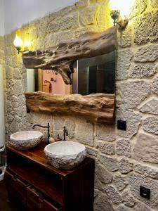 uma casa de banho em pedra com 2 lavatórios e um espelho em Le secret d’Adam em Rouen