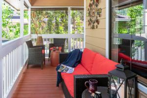 a screened in porch with a red couch on it at Sheridan House Inn- Adult Only Accommodation in Williams