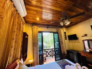 a bedroom with a bed and a ceiling fan at Anisa Mekong Riverside Villa in Luang Prabang +164 photos