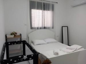a white room with a bed and a window at Luna place in Eilat